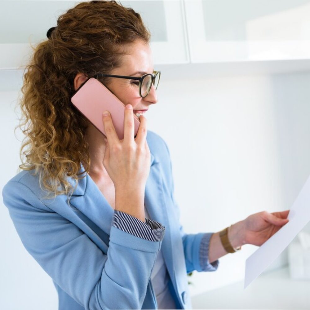 beautiful-young-businesswoman-using-her-mobile-phone-office_1301-7793